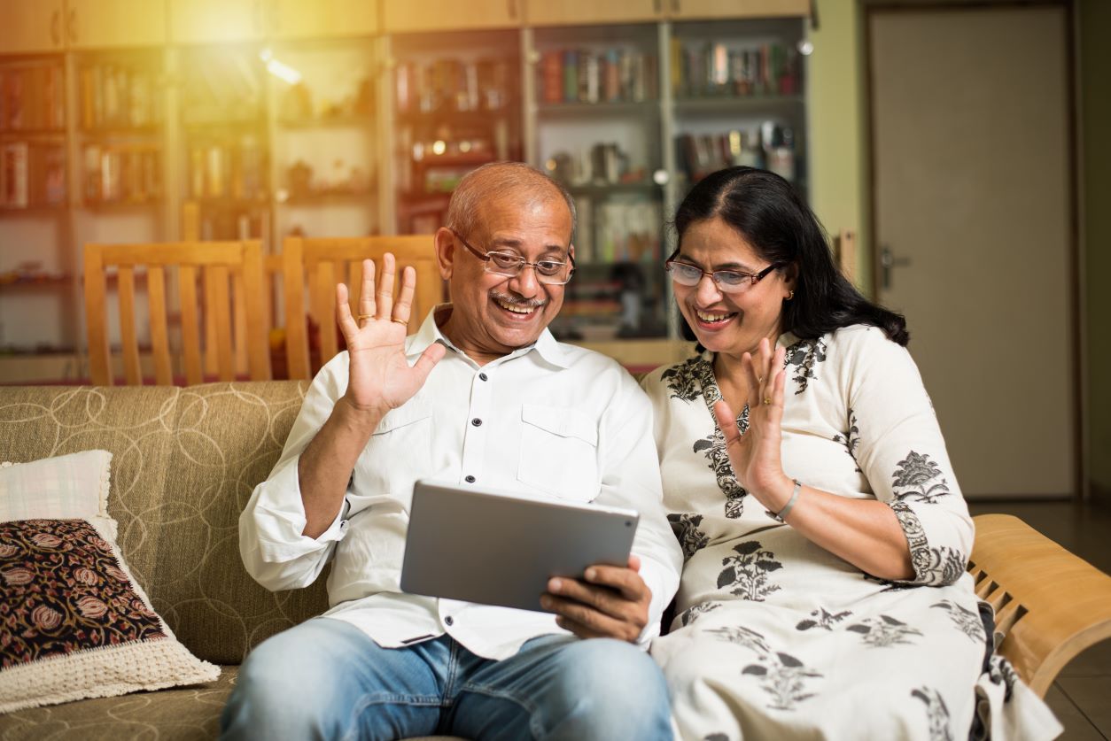 Male and female couple using a tablet for a video call.